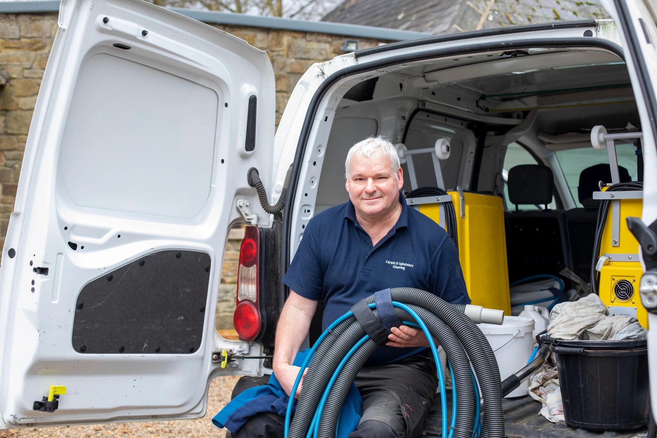 Plumbing service professional seated by a service van